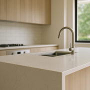Modern kitchen with light engineered stone benchtop and waterfall end